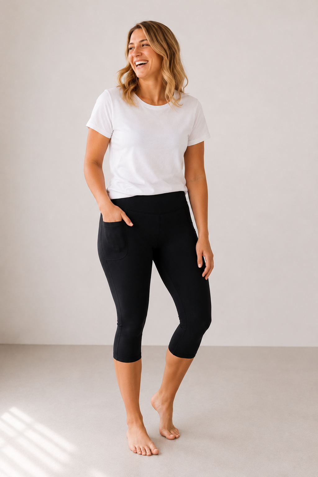 Woman wearing Barefoot & Busy Midnight Black capri leggings with deep side pockets and a white t-shirt.